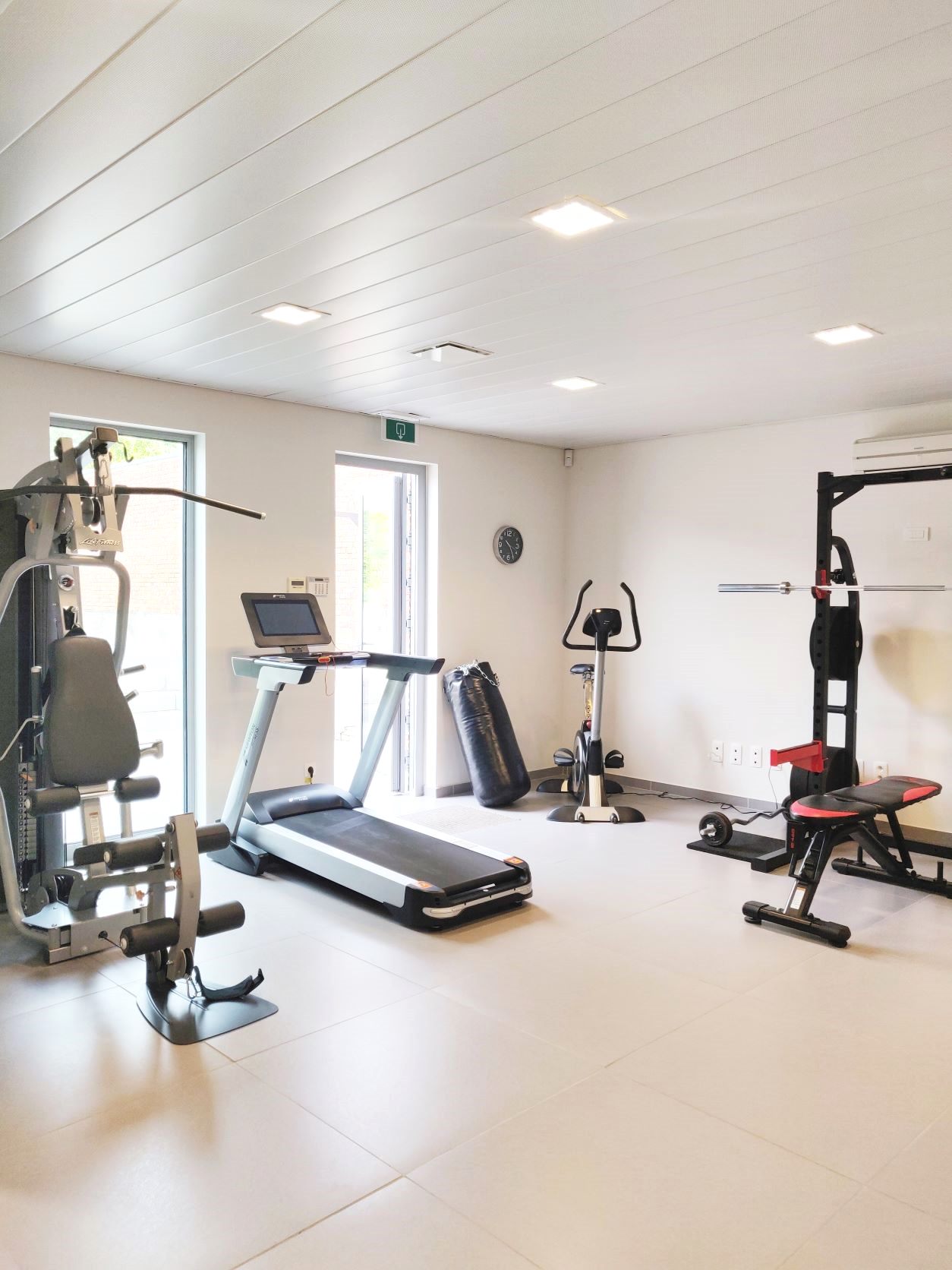 Oefenruimte met bokszak en krachtmateriaal bij Revive Health Center